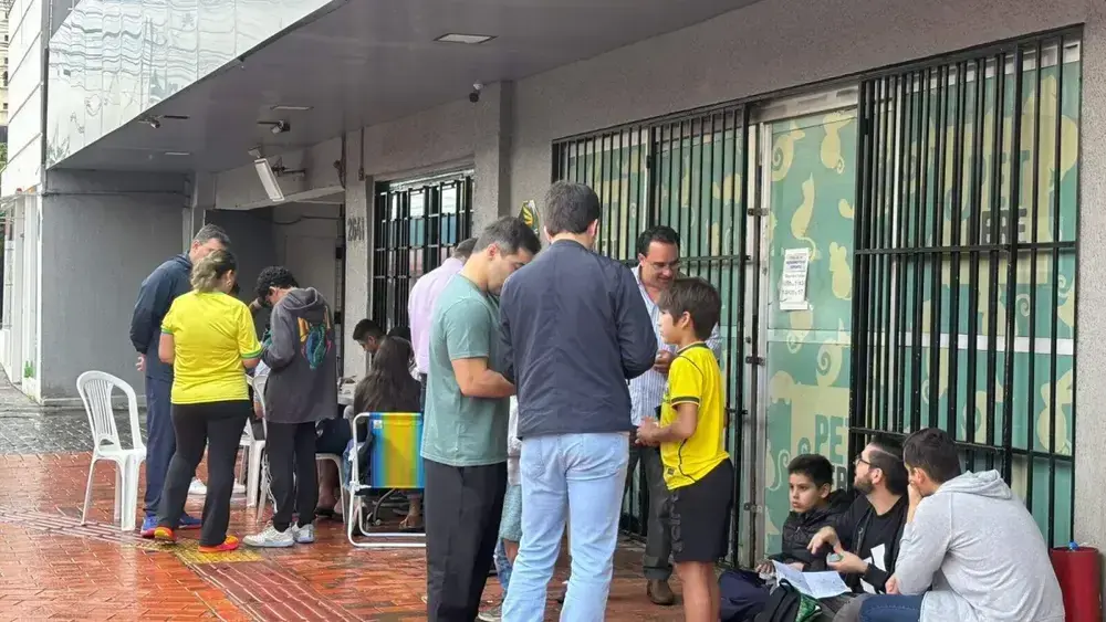 Chuva e jogo do Brasil não param crianças em troca de figurinhas