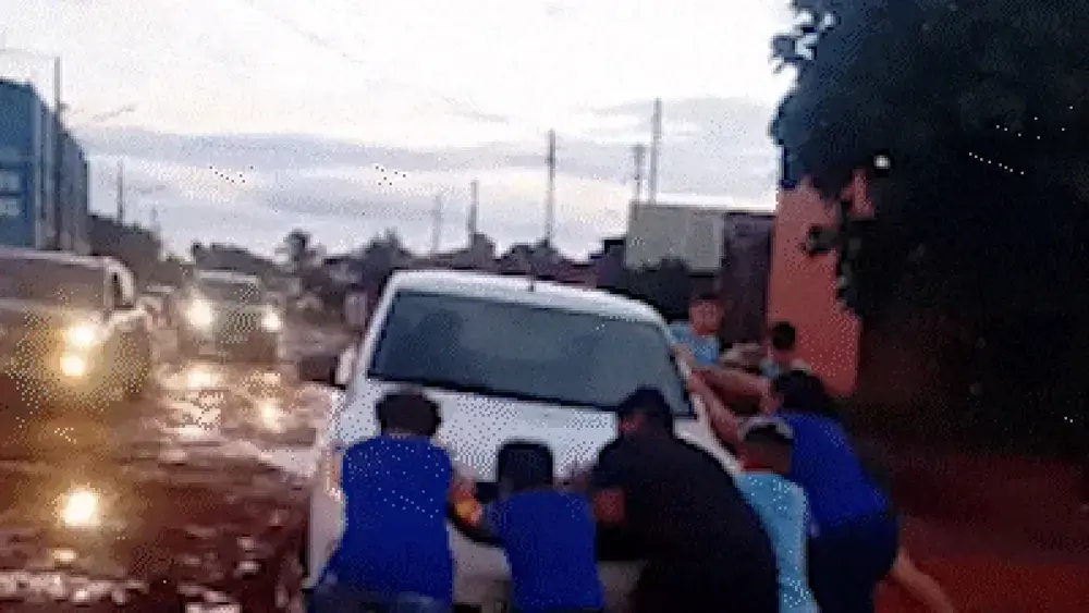 Crianças ajudam motorista a tirar carro de atoleiro em Campo Grande